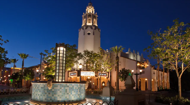 Night view of Carthay Circle Restaurant and Lounge at Disney California Adventure Park, beautifully lit with palm trees and art deco architecture.