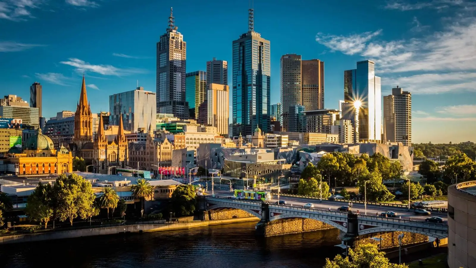 Melbourne cultural capital: Melbourne city skyline at sunset with modern skyscrapers, historic architecture, and Princes Bridge over the Yarra River, Australia