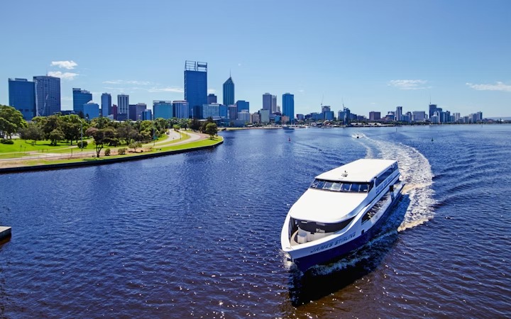 Darling Harbour's family-friendly attractions: Tourist cruise boat sailing along the Swan River with the Perth city skyline in the background on a sunny day