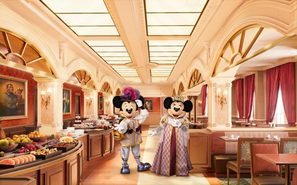 "Mickey and Minnie Mouse dressed in royal costumes posing inside an elegant Disney-themed restaurant with buffet breakfast and classic décor at Disneyland Paris"