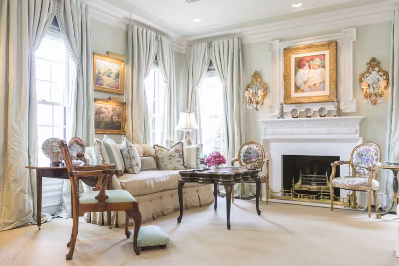 Elegant living room with classic furniture, pastel curtains, a decorative fireplace, and luxury interior design.