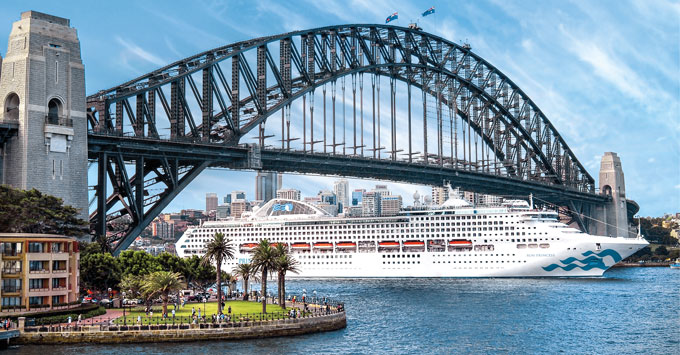 Sydney Harbour Bridge climb or cruise:"Large white cruise ship sailing under the Sydney Harbour Bridge with city skyline and waterfront park in the background on a clear day"