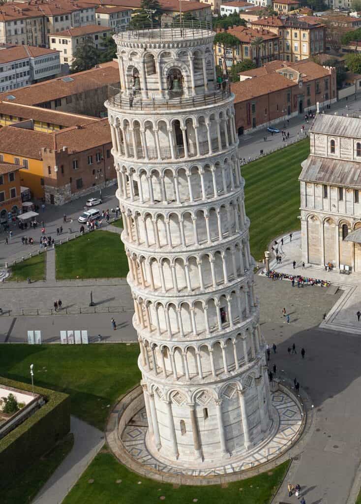 "Aerial view of the Leaning Tower of Pisa in Piazza dei Miracoli, Italy, showing the tower’s famous tilt and surrounding historical buildings on a sunny day"