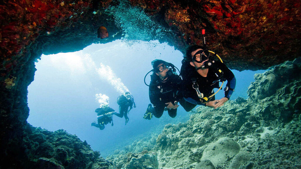 Thailand Phi Phi Islands
"A group of scuba divers exploring an underwater cave surrounded by coral reefs in the clear blue waters of Thailand"