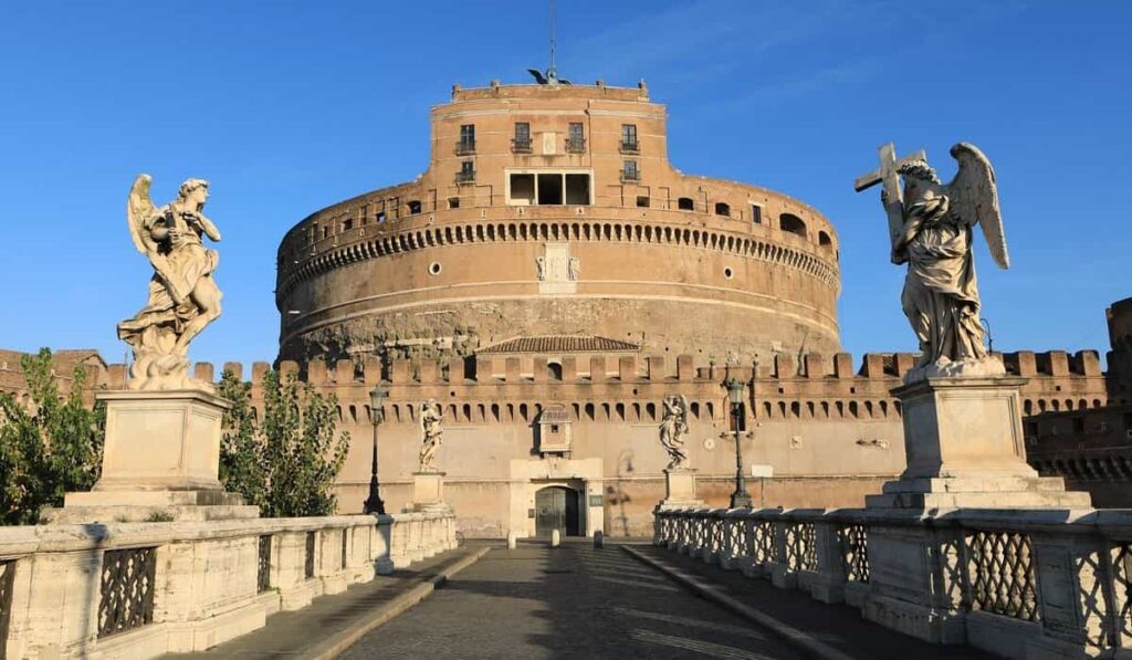 "Castel Sant’Angelo in Rome, Italy, with angel statues on Ponte Sant’Angelo bridge under a clear blue sky"