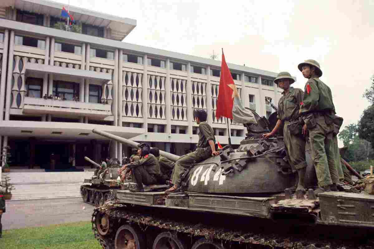 "North Vietnamese Army tanks with soldiers entering the Presidential Palace in Saigon during the Fall of Saigon in April 1975, marking the end of the Vietnam War"