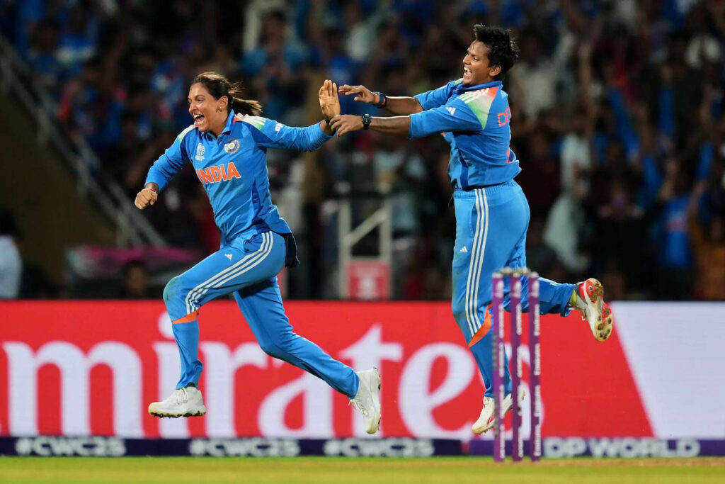 Indian women’s cricket players celebrating a wicket during the World Cup match with joyful expressions and energy at DY Patil Stadium.
