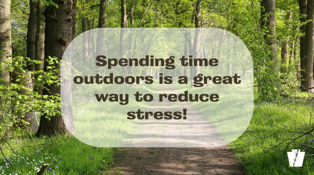 "Forest pathway surrounded by green trees with a message overlay saying 'Spending time outdoors is a great way to reduce stress,' highlighting the mental health benefits of nature."