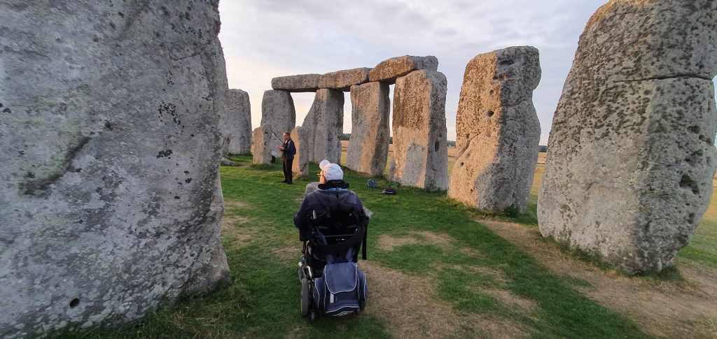 "Visitor in a wheelchair exploring the ancient standing stones of Stonehenge in Wiltshire, England, showcasing accessibility at the prehistoric UNESCO World Heritage Site"